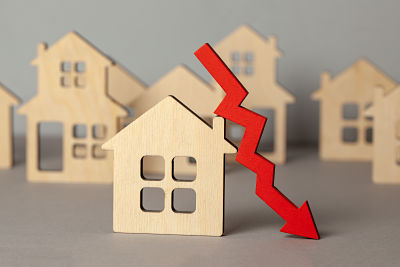 Arrow down and many houses symbolising market crisis