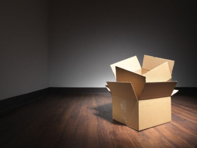 Shot of empty boxes on the floor of an empty room during a house move. The boxes have been lit with a spot so the rest of the rooom goes dark and the designer can use light type over darker areas if needed. The halo is natural and has not been achieved by the use of post production adjustments.