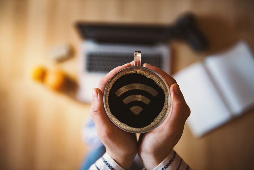 Girl holding a cup of coffee with wi-fi symbol.