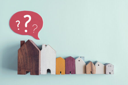 Wooden houses with question marks, housing crisis, confused decision, insecure investment, choosing right property concept