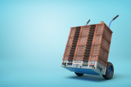 3d rendering of small 16-storeyed block of flats on blue hand truck on light-blue background. Flats for sale. Solve housing problem. City redesign.