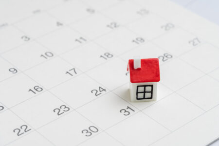 Housing, property or real estate or mortgage payment concept, miniature house with red roof on the end of month 31th date white clean calendar.
