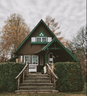 A green house with stairs leading up to it