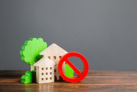 Wooden houses and a stop sign indicating rent freezes
