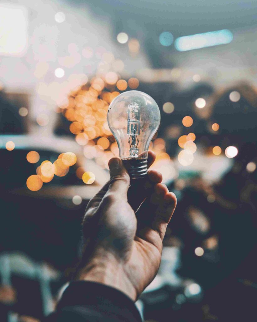 A hand holding a light bulb