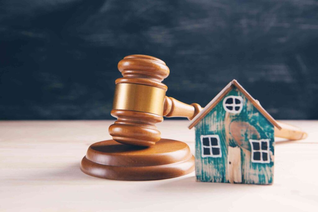 Judge gavel and houses on a wooden background. The concept of a real estate auction,