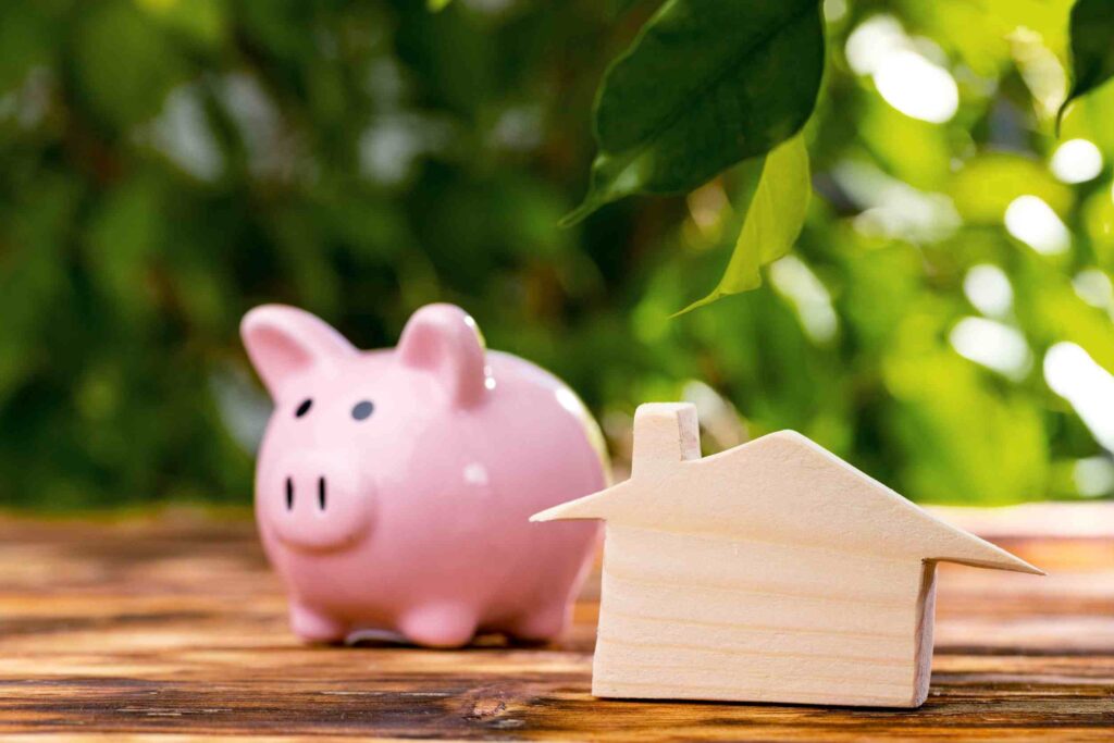 Piggy bank, background of leaves, wooden house