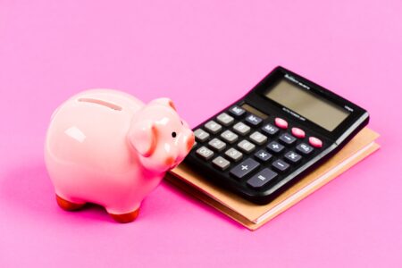 Piggy bank pink pig and calculator.