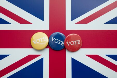 Union flag background with yellow, blue and red voting buttons